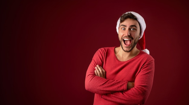 Young handsome guy in red sweater and Santa hat