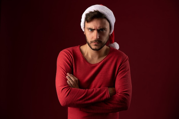 Young handsome guy in red sweater and Santa hat