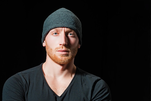 Young handsome hipster in hat Barbershop advertising Portrait of sporty handsome masculine virile attractive proud concentrated confident muscular man Copy space In casual dark t shirt