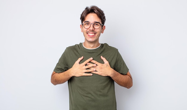 Young handsome hispanic man looking happy, surprised, proud and excited, pointing to self