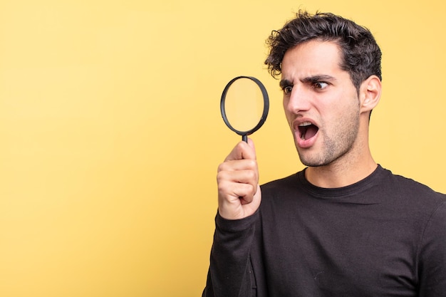 young handsome hispanic man. magnifying glass concept