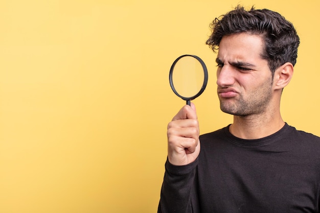 Young handsome hispanic man magnifying glass concept