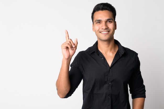 young handsome Indian businessman against white wall