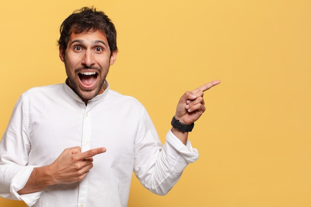 Young handsome indian man. shocked or surprised expression