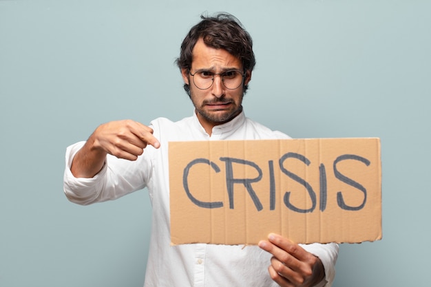 Photo young handsome indian man with crisis banner