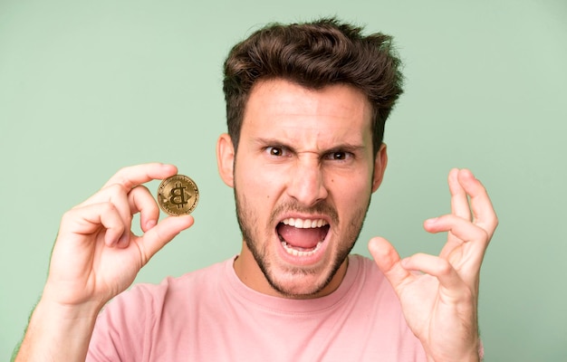 Young handsome isolated man with a bitcoin coin