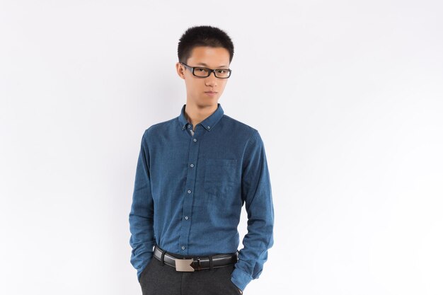 Young handsome male in blue shirt in front of white background