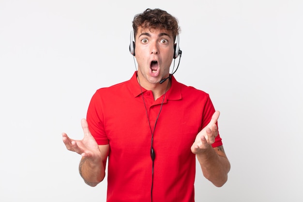 Young handsome man amazed, shocked and astonished with an unbelievable surprise. telemarketer concept