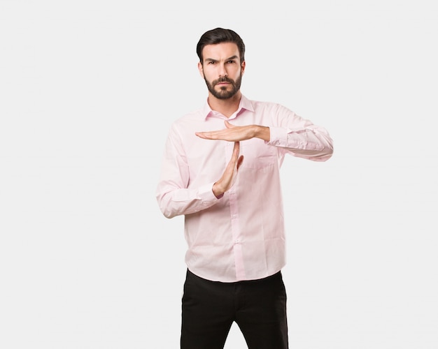 Young handsome man doing a timeout gesture