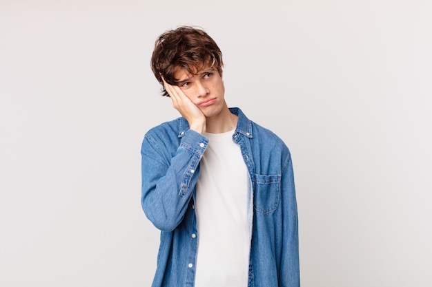 young handsome man feeling bored, frustrated and sleepy after a tiresome