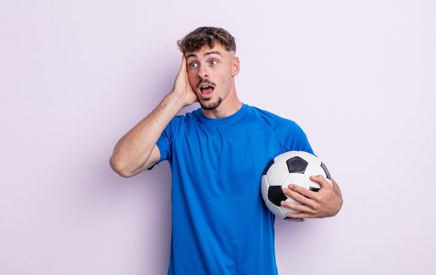 Young handsome man feeling happy, excited and surprised. soccer concept