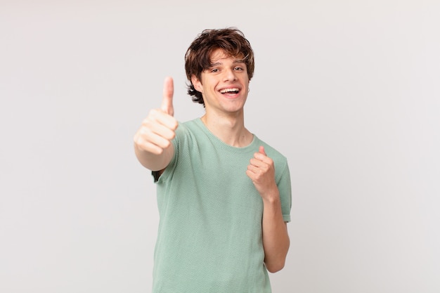 Young handsome man feeling proud,smiling positively with thumbs up