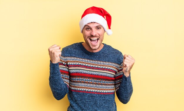 Young handsome man feeling shocked,laughing and celebrating success. christmas concept