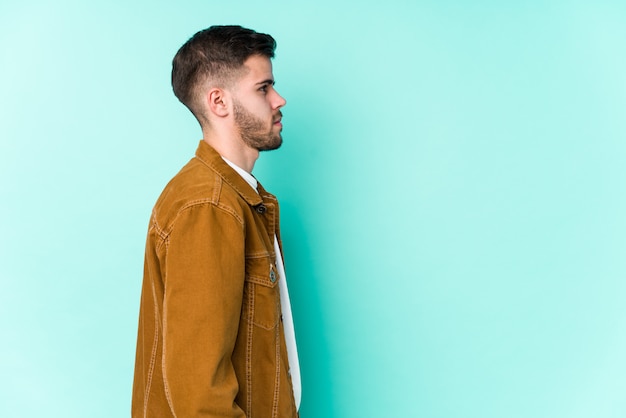 Young handsome man gazing left, sideways pose.