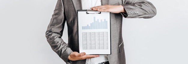 Young handsome man in glasses in suit with business documents and charts on white isolated background