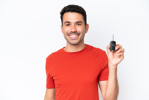 Young handsome man holding car keys over isolated white background smiling a lot