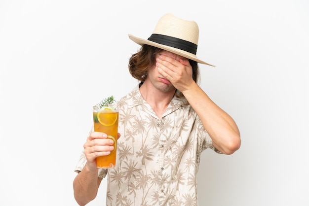 Young handsome man holding a cocktail isolated on white background with tired and sick expression