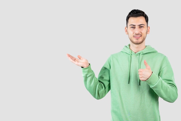 young handsome man in hoodie giving thumbs up