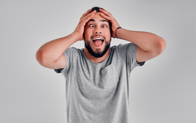 Young handsome man over isolated background Crazy and scared with hands on head, afraid and surprised of shock with open mouth