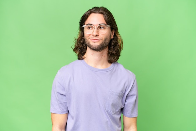 Young handsome man over isolated background having doubts while looking side