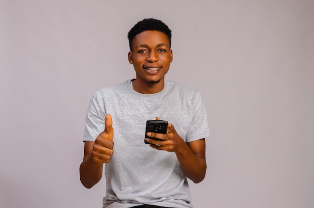 Young handsome man over isolated background sending a message or email with the mobile