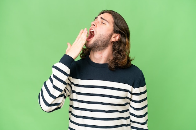 Photo young handsome man over isolated background yawning and covering wide open mouth with hand