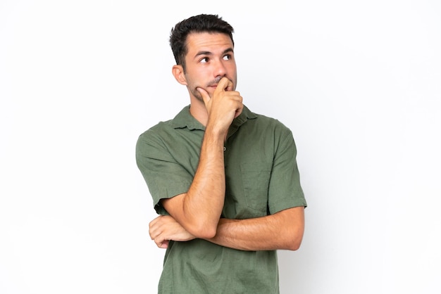 Young handsome man over isolated white background having doubts and with confuse face expression