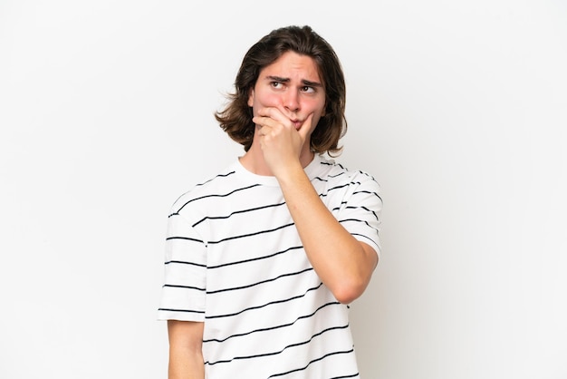 Young handsome man isolated on white background having doubts and with confuse face expression