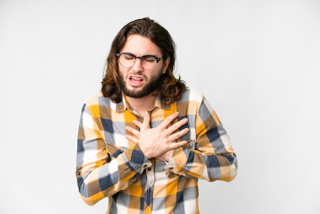 Young handsome man over isolated white background having a pain in the heart