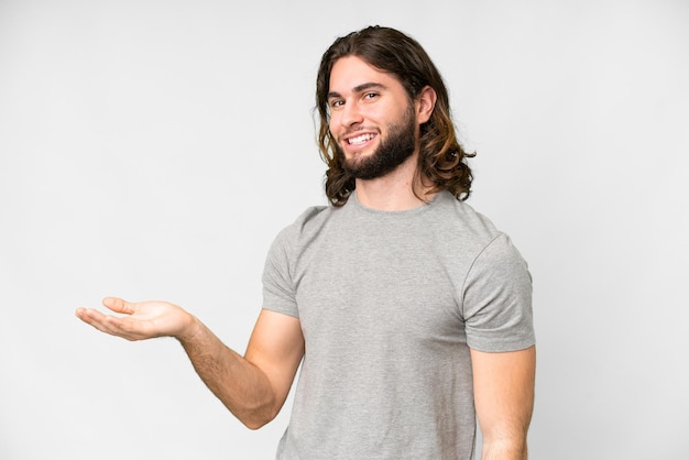 Young handsome man over isolated white background presenting an idea while looking smiling towards