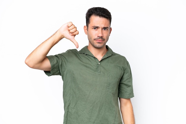 Young handsome man over isolated white background showing thumb down with negative expression