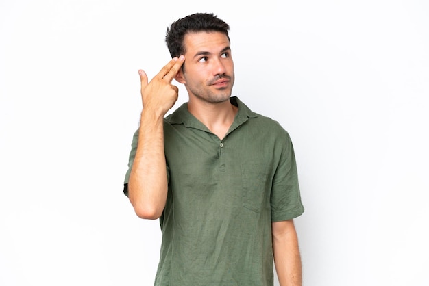 Young handsome man over isolated white background with problems making suicide gesture