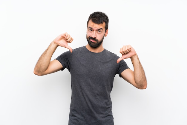 Young handsome man over isolated white showing thumb down