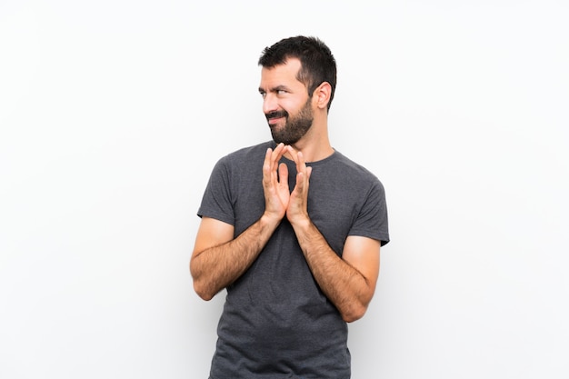 Young handsome man over isolated white wall scheming something