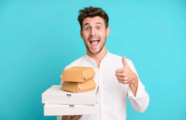 Young handsome man isolated with fast food mock up boxes delivery and take away concept