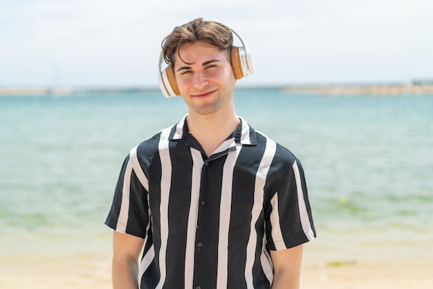 Young handsome man listening music with headphones at outdoors