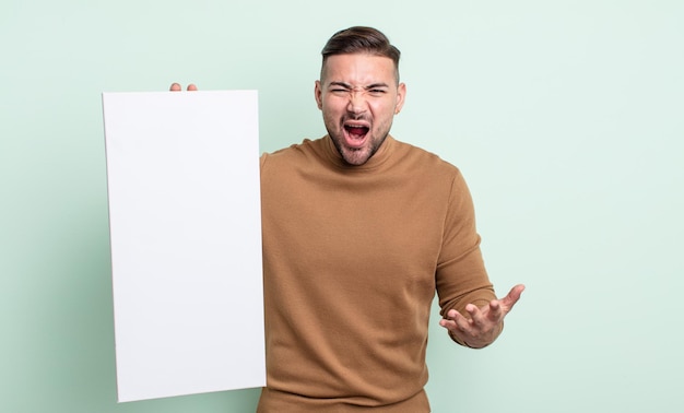 Young handsome man looking angry, annoyed and frustrated. empty canvas concept