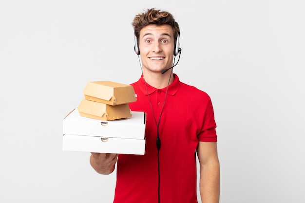 Young handsome man looking happy and pleasantly surprised. take away fast food concept