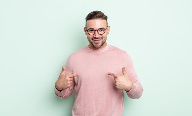 Young handsome man looking proud, arrogant, happy, surprised and satisfied, pointing to self, feeling like a winner