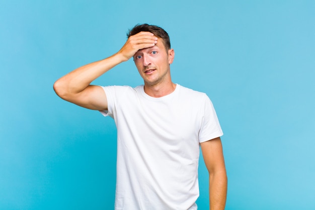 Young handsome man panicking over a forgotten deadline, feeling stressed, having to cover up a mess or mistake