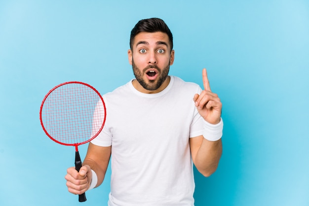 Young handsome man playing badminton isolated having some great idea, concept of creativity.