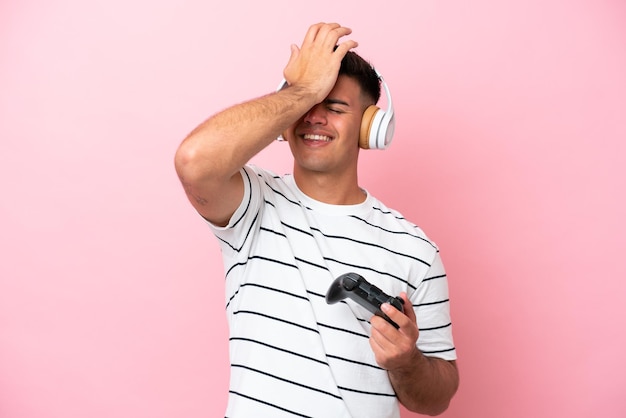 Young handsome man playing with a video game controller isolated on pink background has realized something and intending the solution