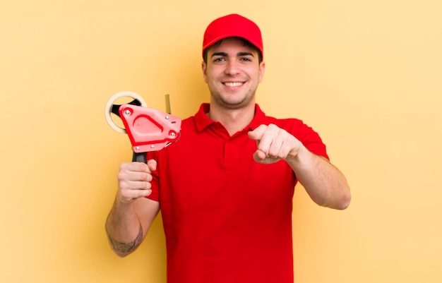 Young handsome man pointing at camera choosing you packer concept