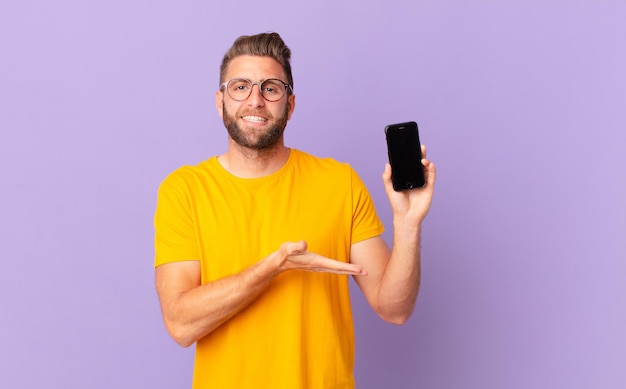 young handsome man smiling cheerfully, feeling happy and showing a concept. cell concept