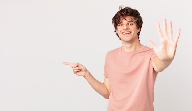 Young handsome man smiling and looking friendly, showing number five