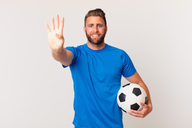 Young handsome man smiling and looking friendly, showing number four. soccer concept