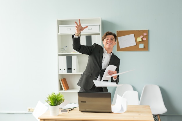 Young handsome man in suit having fun in the office