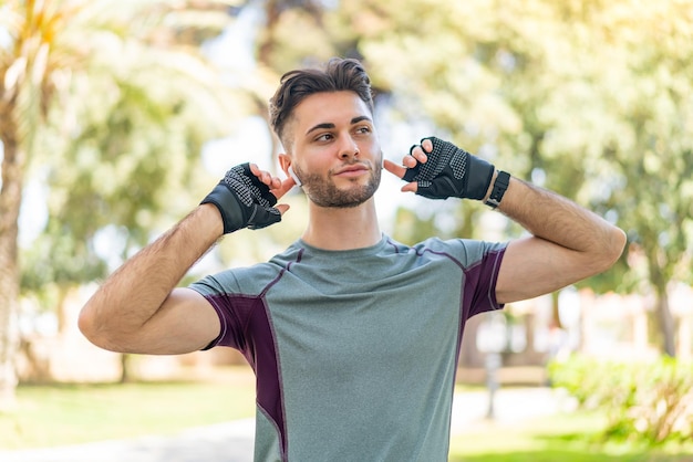 Young handsome man wearing sport wear and listening music with wireless headphones