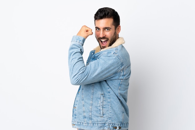 Young handsome man with beard isolated on white doing strong gesture