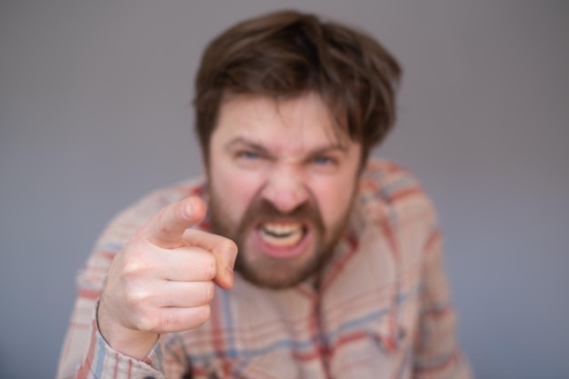 Young handsome man with beard pointing displeased and frustrated to the camera